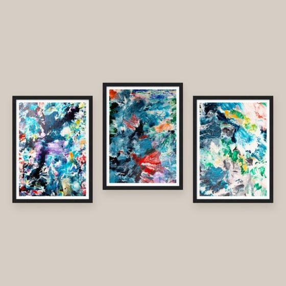 Drei gerahmte Kunstdrucke nebeneinander an einer beigen Wand